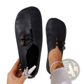 Women’s black leather slip-on shoes with gold-tone buttons and silver butterfly charm side detail