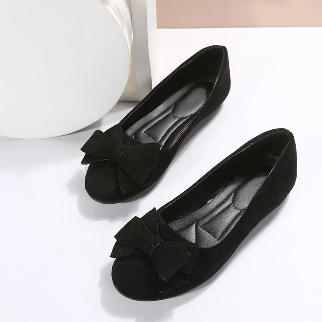 Women’s black suede gommino loafers with bow detail on the round toe for elegant flat wear
