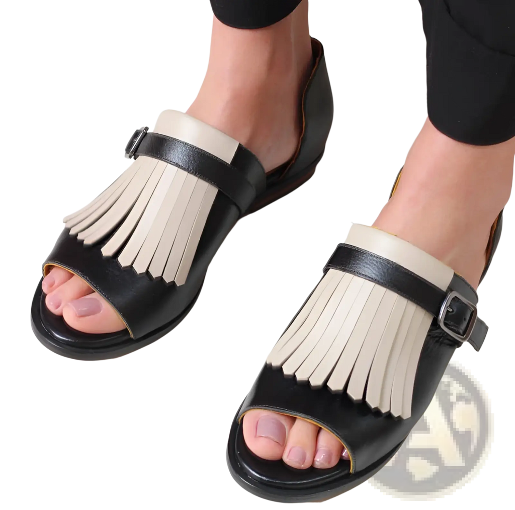 Women’s tassel leather beach sandals in black and cream featuring a fringed design and soft leather material