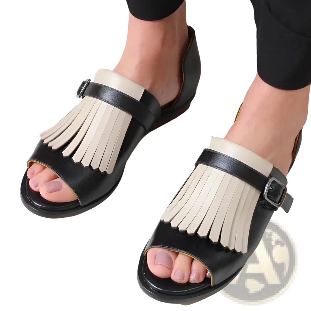 Women’s tassel leather beach sandals in black and cream featuring fringe detail on soft leather straps
