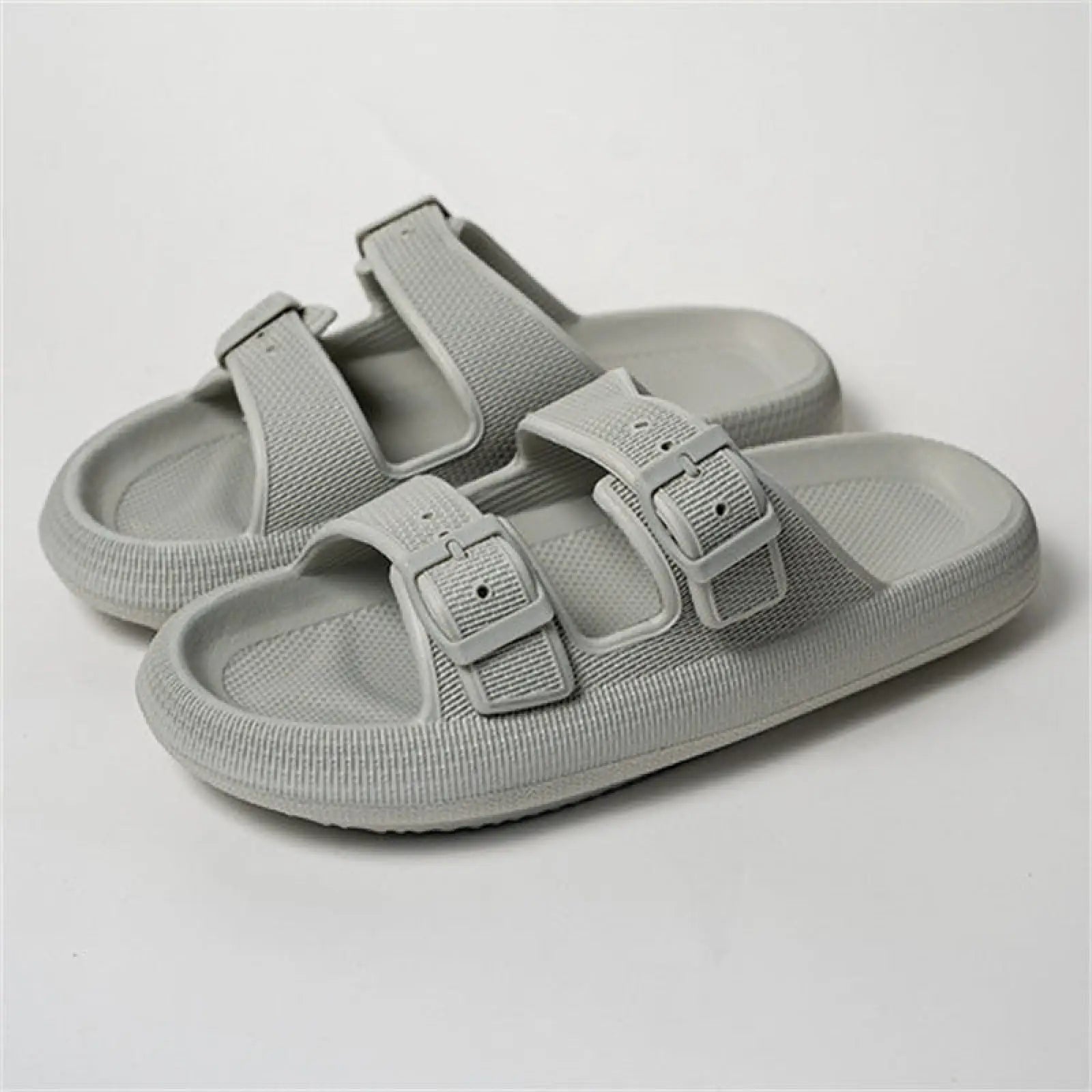 Light gray women’s two-strap slide sandals with breathable textured fabric upper and thick molded rubber sole