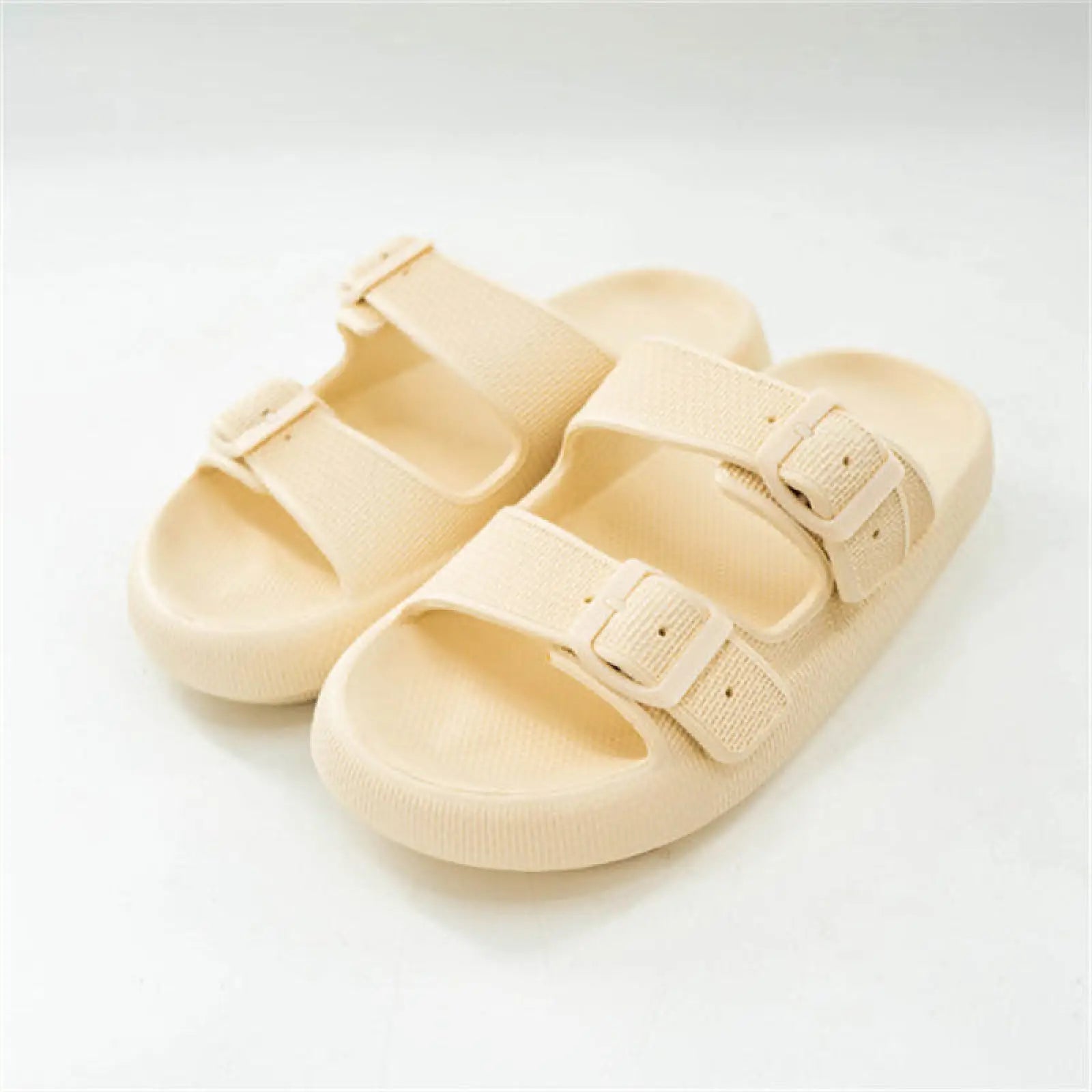 Cream-colored women’s thick sole breathable eva massage slide sandals with two fabric-like straps and a rubber sole