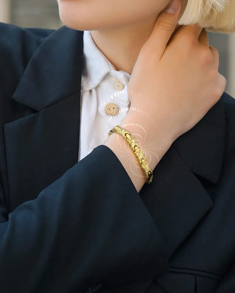 Gold-toned intricately linked stainless steel Gold Crystal Xo magnetic bracelet worn on a wrist