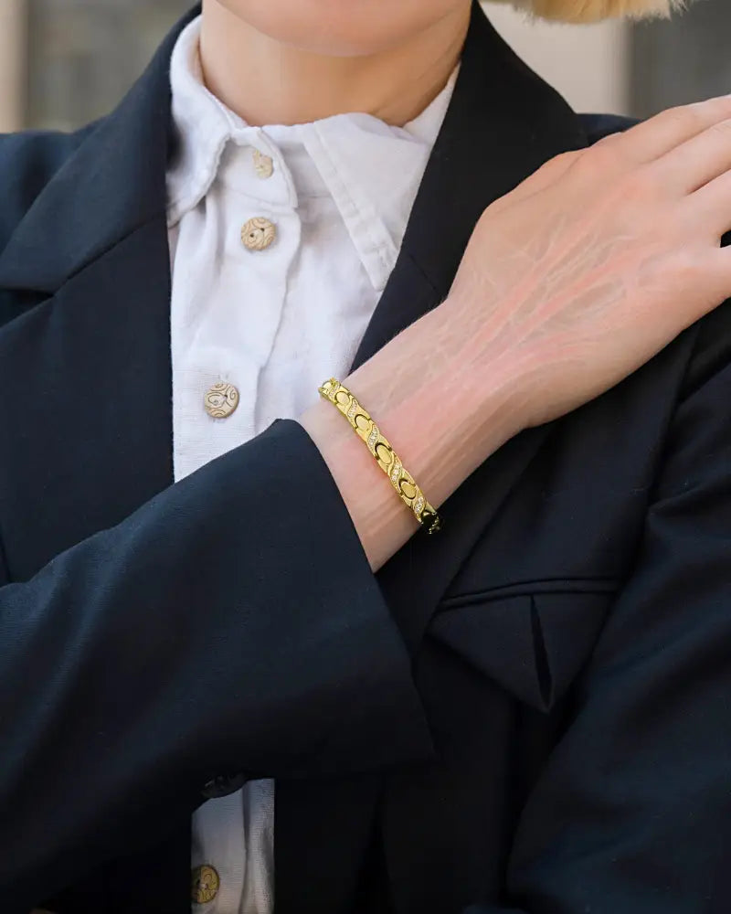 Gold crystal xo magnetic stainless steel bracelet with gold-toned interlocking links and a sleek modern design