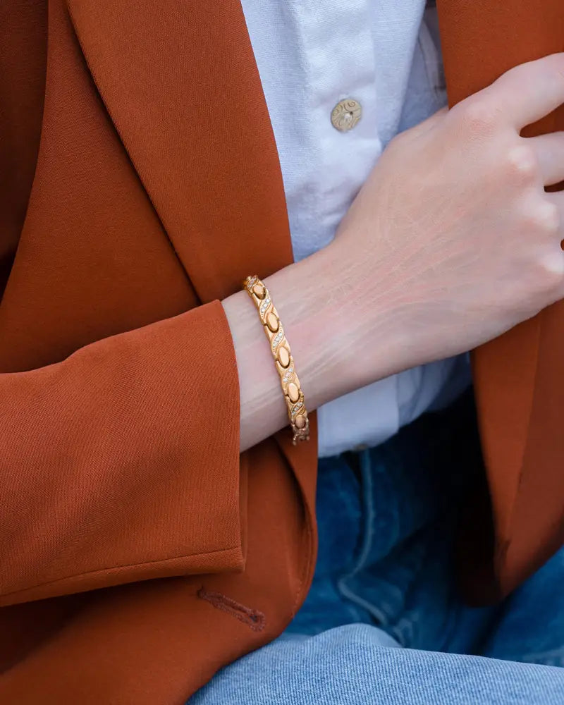 Women’s rose gold magnetic crystal xo link bracelet with sleek gold-toned interlocking oval links worn on wrist