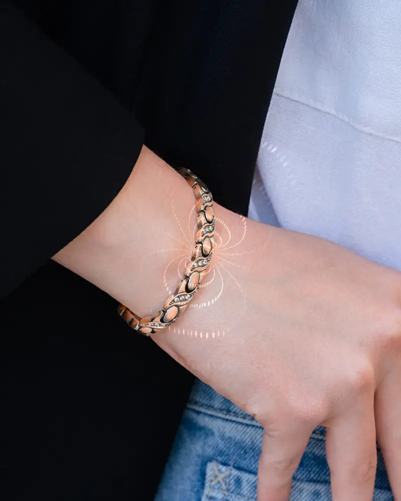 A delicate rose gold pure copper magnetic crystal bracelet with linked oval design and embedded clear stones