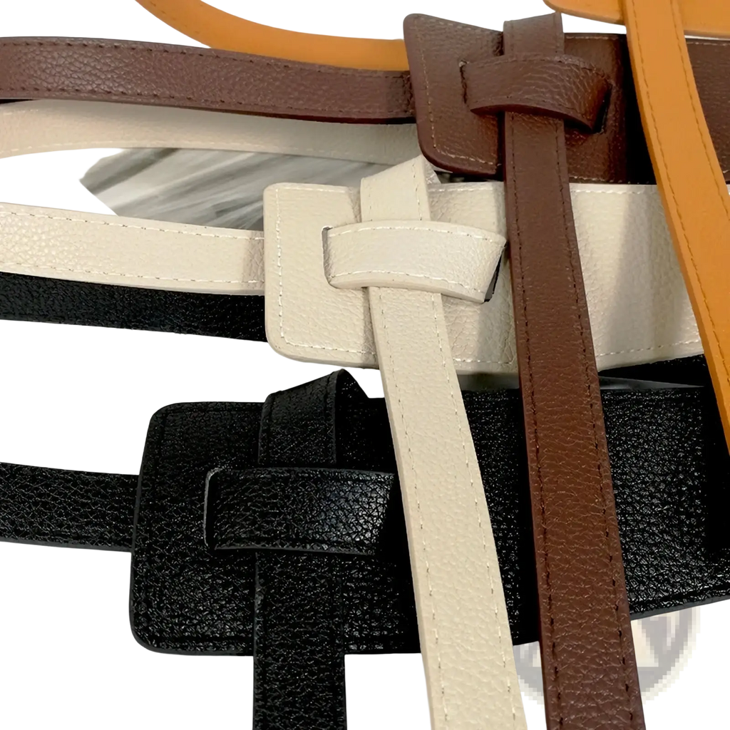 A collection of women’s wide pu leather knot waist belts in black beige and brown with textured surfaces and rectangular buckles