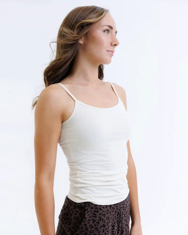 A white sleeveless cotton stretch wonder cami tank top with thin straps and ruched front for layering