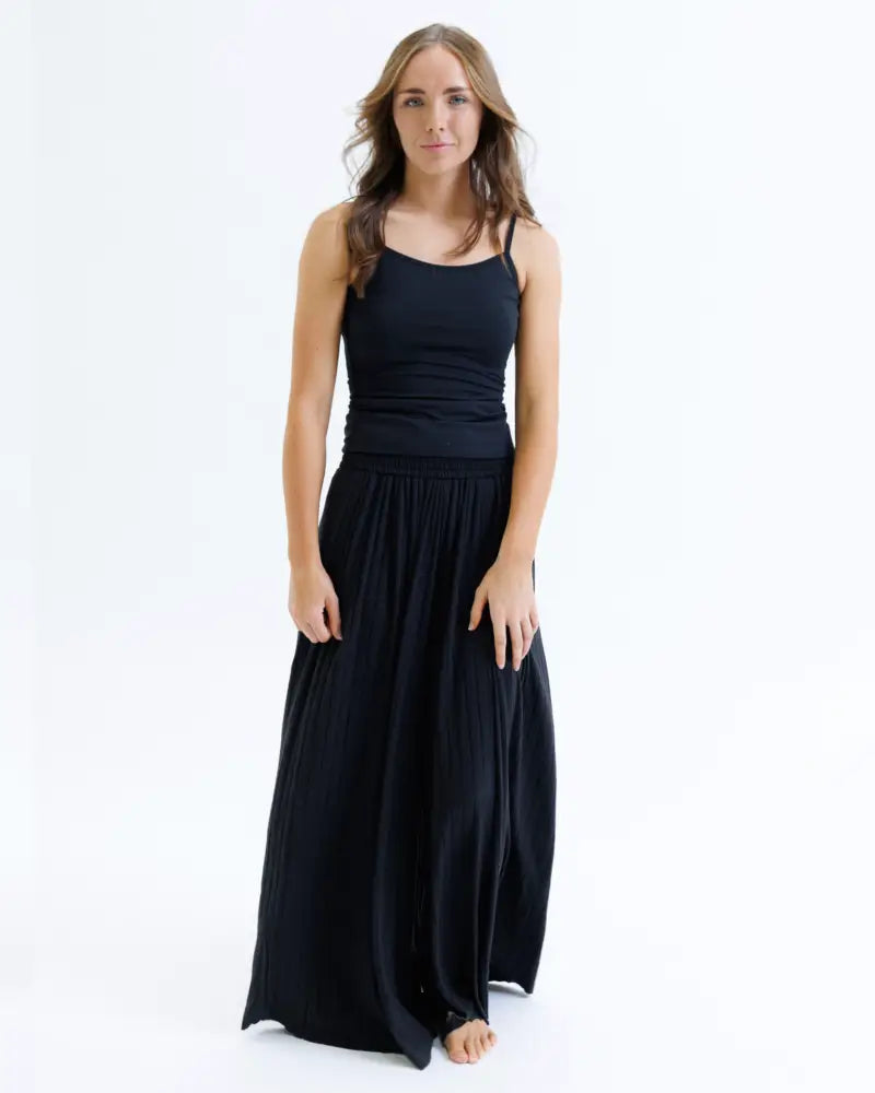 Black sleeveless maxi dress with thin straps and a flowing pleated skirt made of cotton stretch fabric