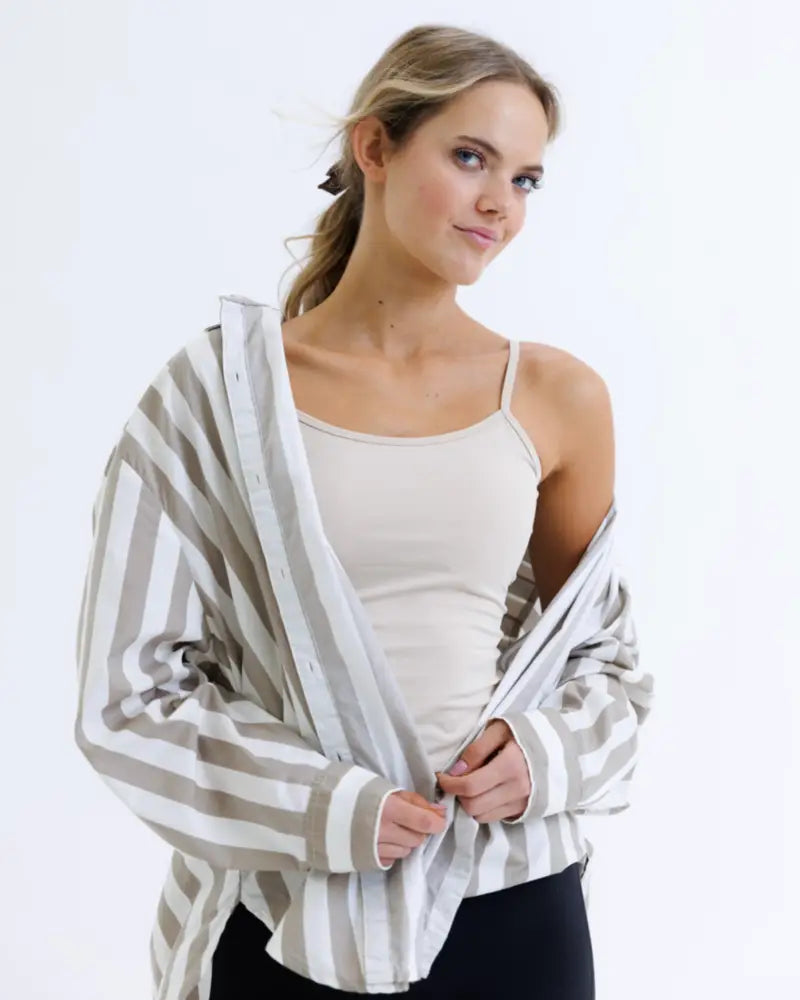 A loose-fitting long-sleeved shirt with gray and white vertical stripes made of cotton stretch fabric