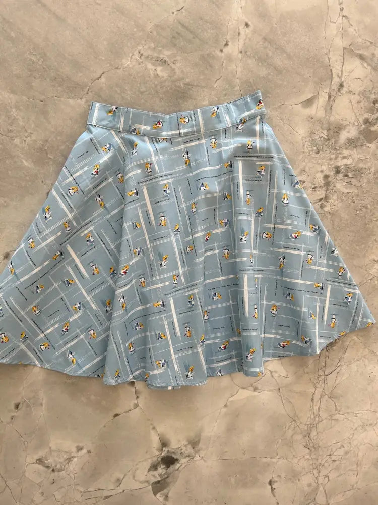 Alice in Wonderland light blue pleated skater skirt with a repeating cartoon character grid pattern