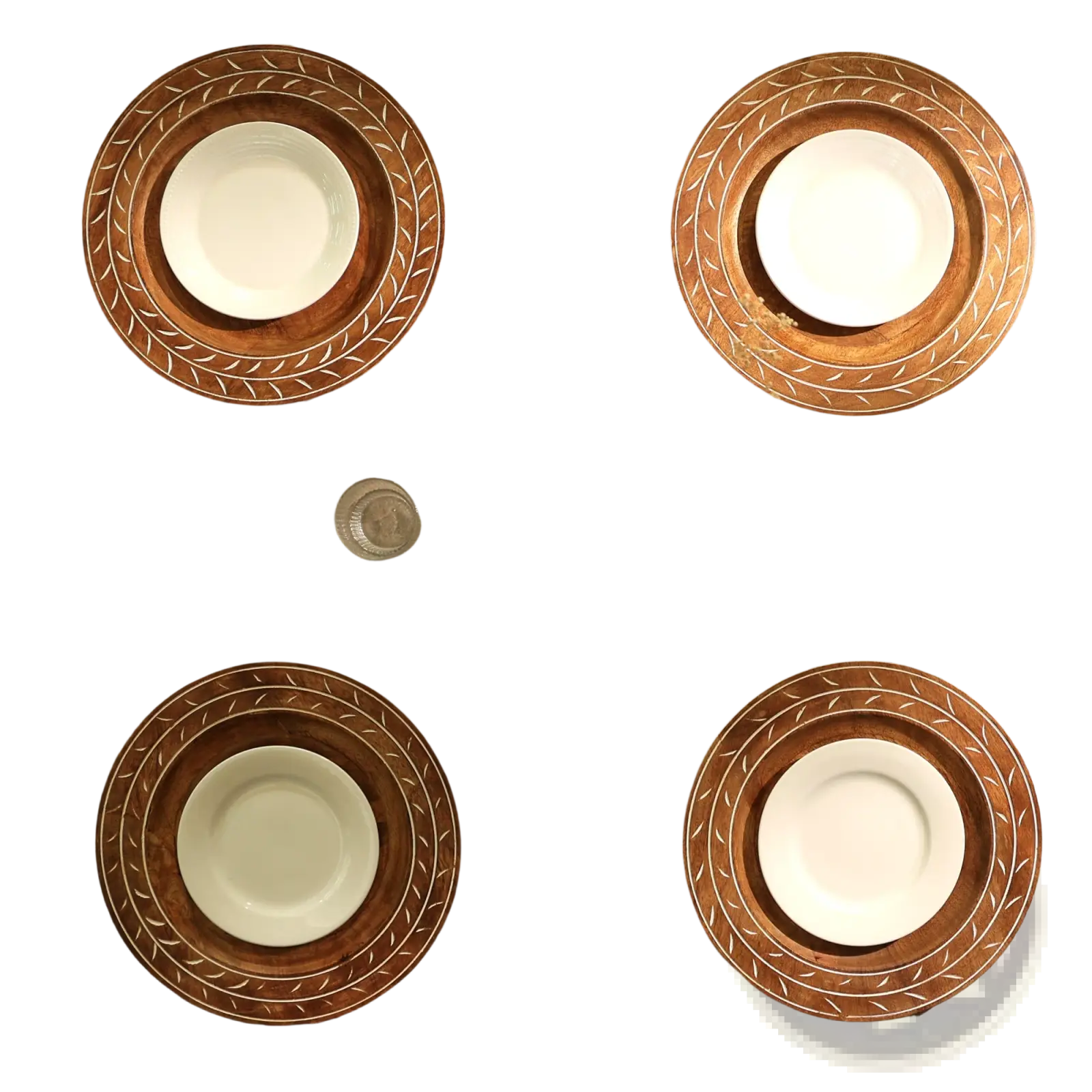 Set of four handcrafted 13 inch wooden charger plates with intricate leaf-patterned borders holding white ceramic bowls
