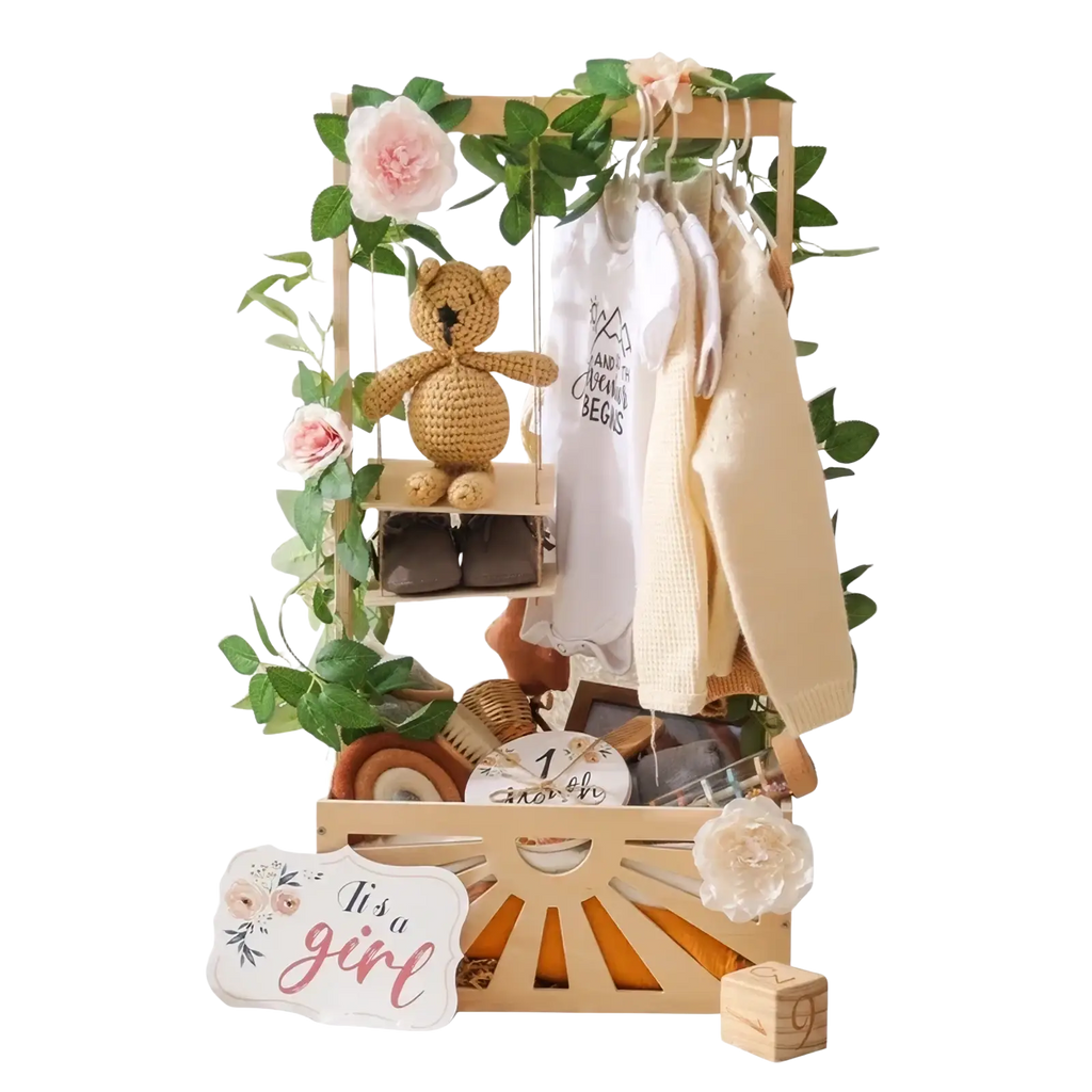 Wooden baby storage basket decorated with greenery pink flowers and a crocheted teddy bear on a swing for nursery decor
