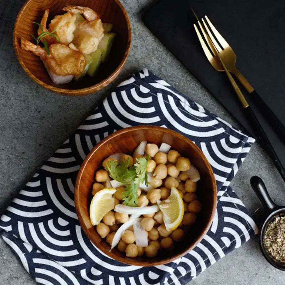 Handcrafted Japanese style natural wooden bowl filled with chickpeas lemon slices and cilantro in light wood color