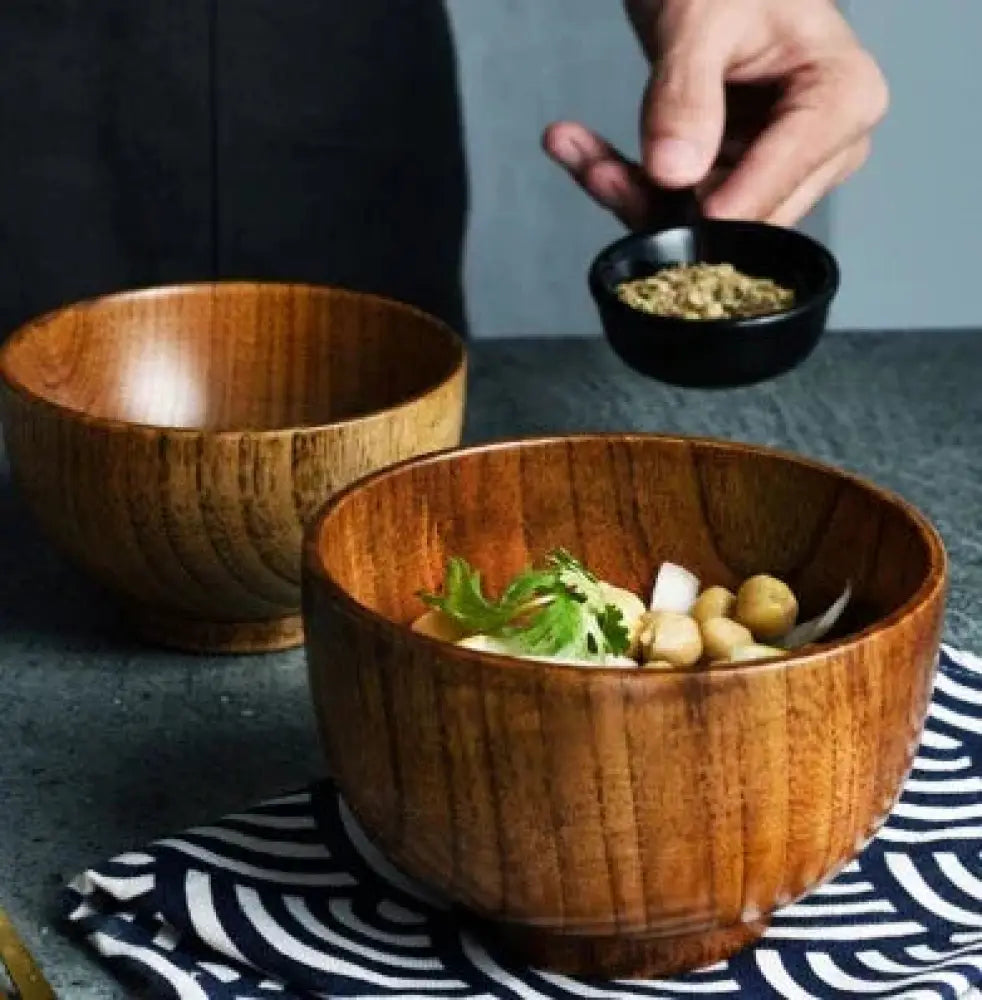 Handcrafted Japanese style natural wooden bowl in warm tones with visible grain and smooth rounded rim