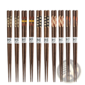 Set of ten pairs of dark brown wooden chopsticks with non slip tips and decorative inlays and white paper bands