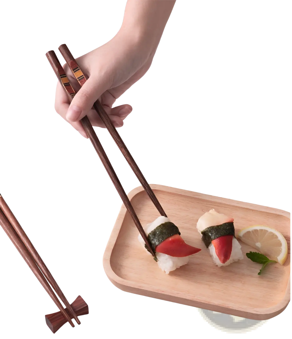 Dark brown wooden chopsticks set with non slip tips featuring a subtle striped pattern held above sushi tray