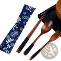 Blue patterned fabric case with white floral design holds wooden cutlery set with chopsticks spoon and fork for travel use