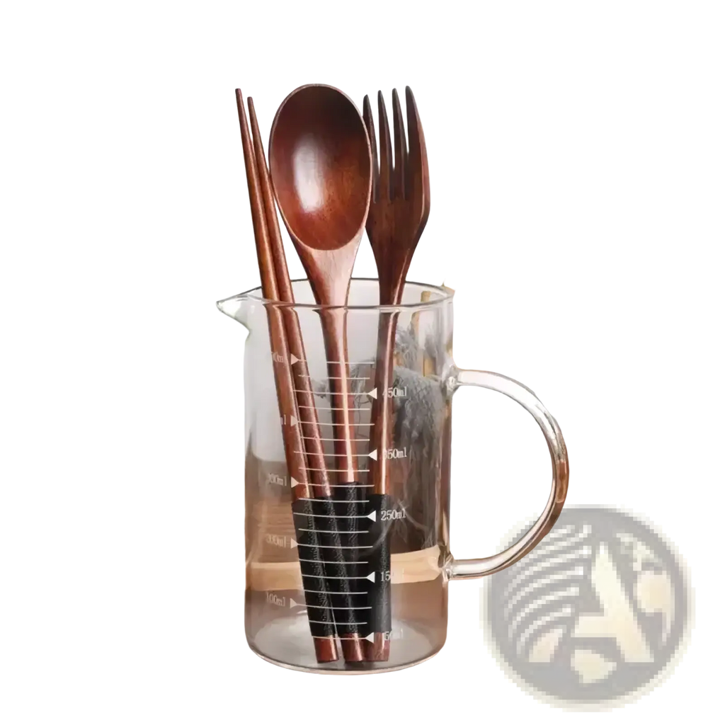 Wooden cutlery set with fork spoon and chopsticks in a clear glass measuring cup with black measurement markings