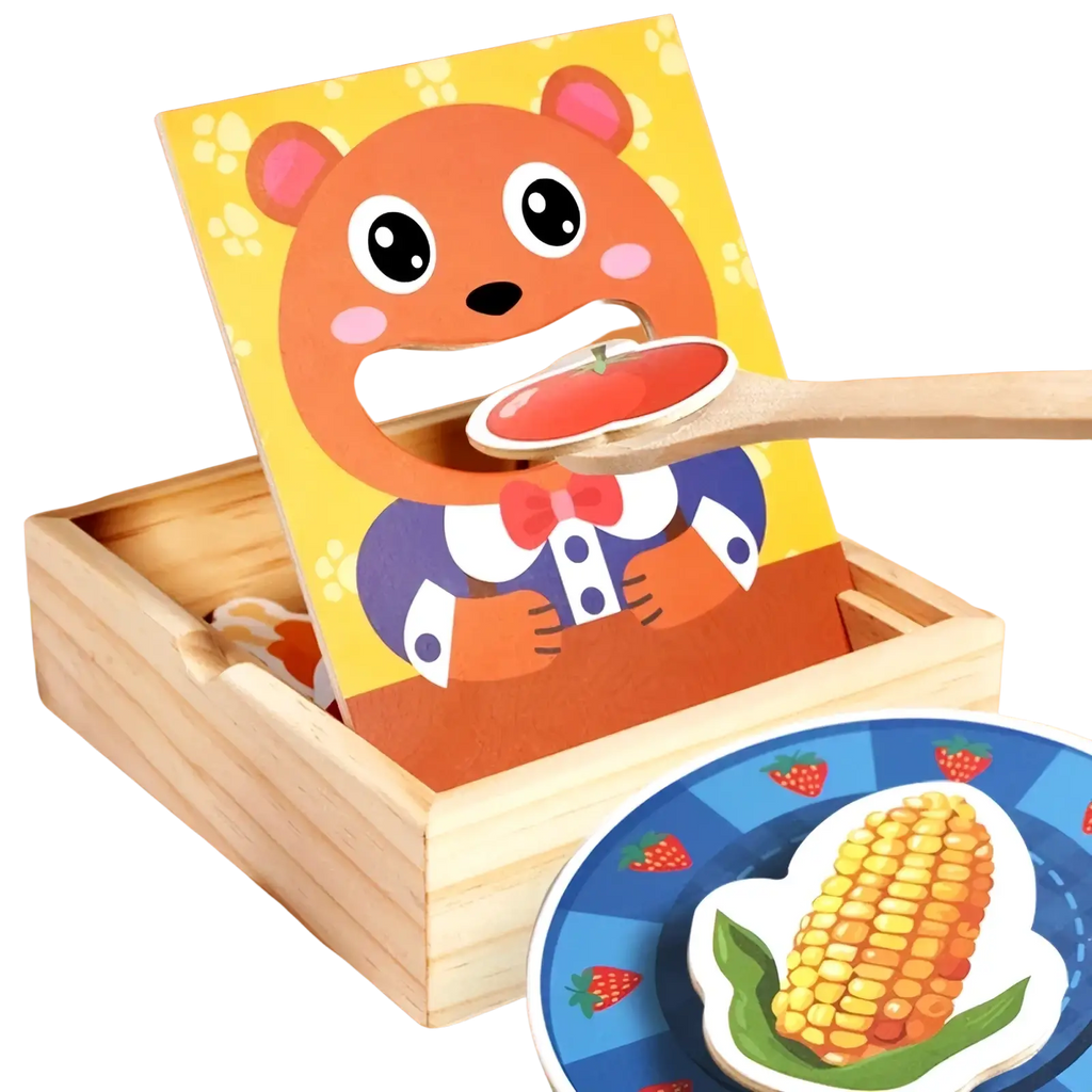 Orange bear-shaped wooden feeding toy with a mouth cutout holding a tomato on a spoon for montessori toddlers