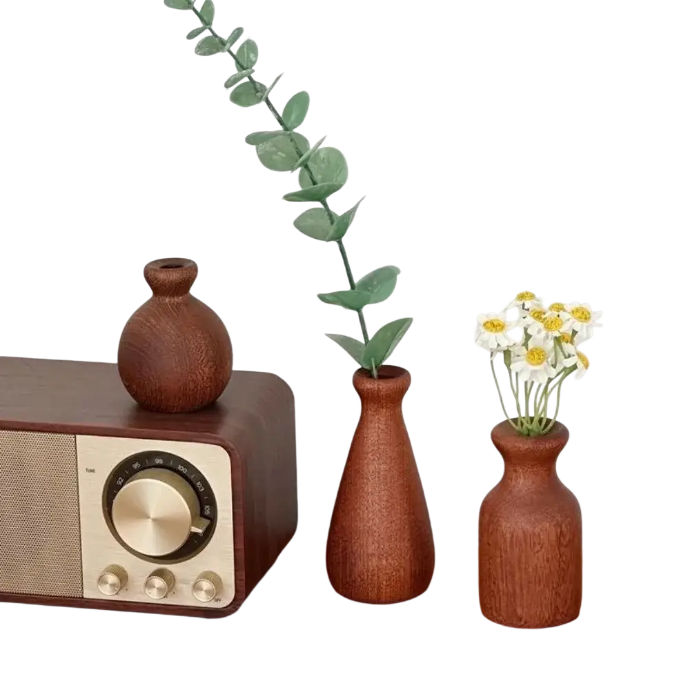 Three rustic wooden flower vases in varying shapes with eucalyptus and white daisies for minimalist tabletop decor