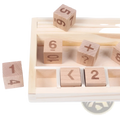 Light-colored wooden number and addition symbol blocks arranged in a matching wooden tray for math learning