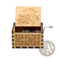 A light wood-colored wooden music box with hand crank and carved beauty and the beast design on the lid