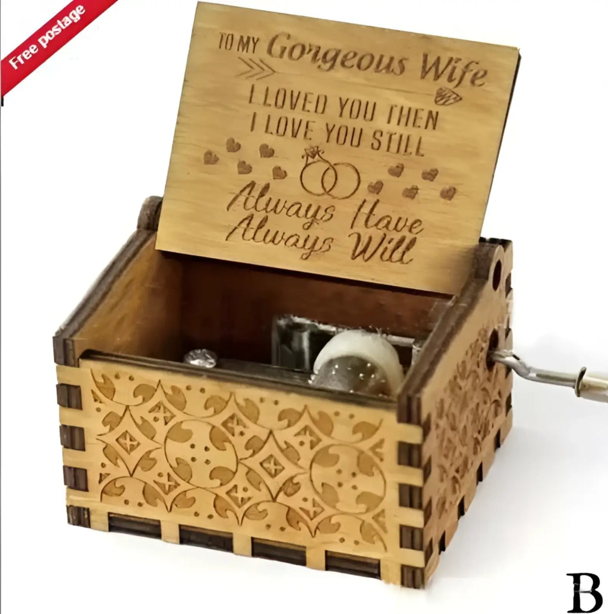A light brown wooden music box with hand crank carved themes and a personalized engraved lid