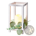 White distressed wood lantern with warm led candle and eucalyptus foliage for wooden wedding centerpiece set