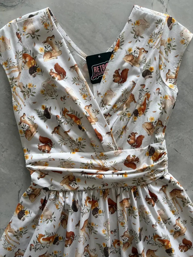 White sleeveless woodland animals greta cotton wrap dress with pockets featuring deer squirrels and flowers print