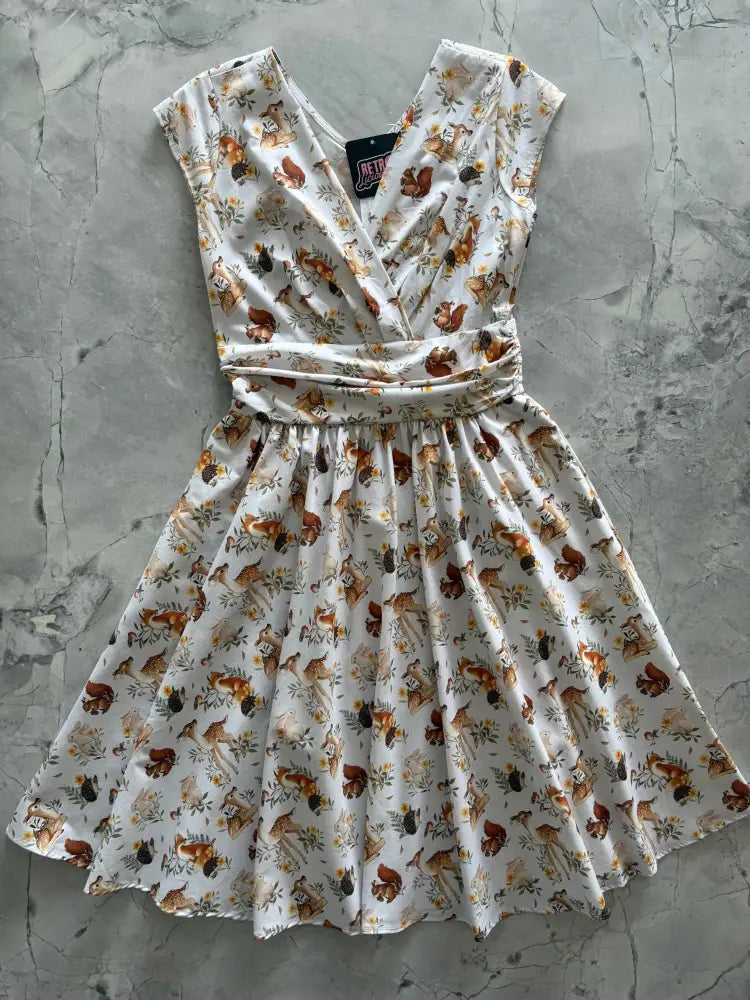 White sleeveless cotton wrap dress with v-neck gathered waist and brown squirrels green foliage pattern with pockets