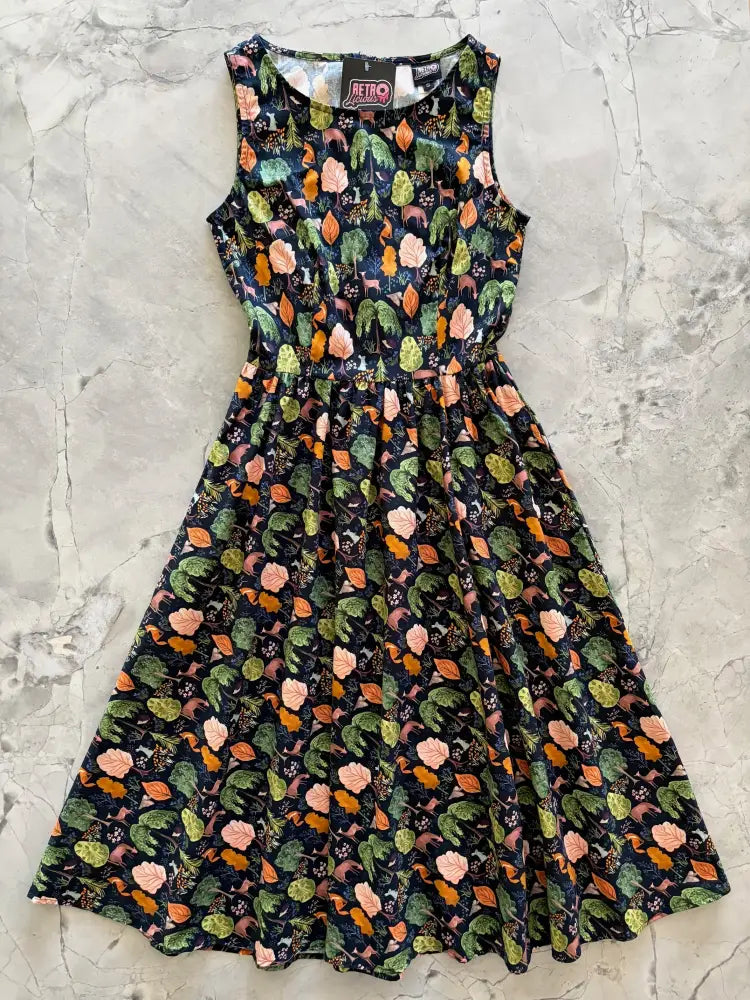 A sleeveless dark navy cotton 1950s style midi dress with vibrant pink rose woodland print and pockets