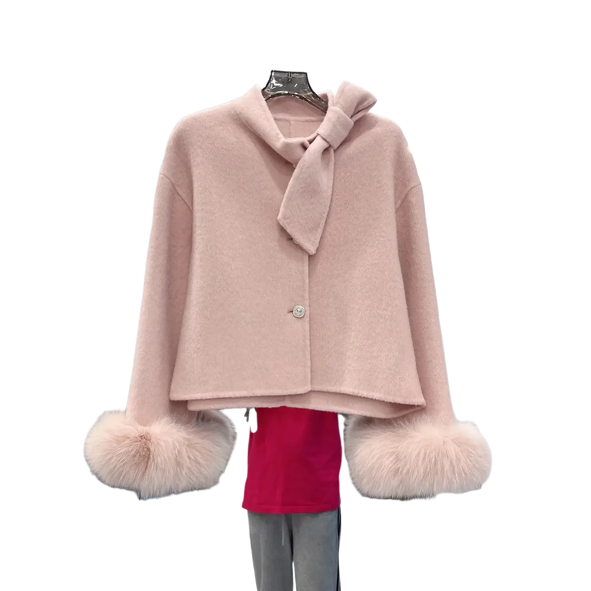 A soft pink wool cropped coat with a bow at the neckline and fluffy fur cuffs for stylish warmth