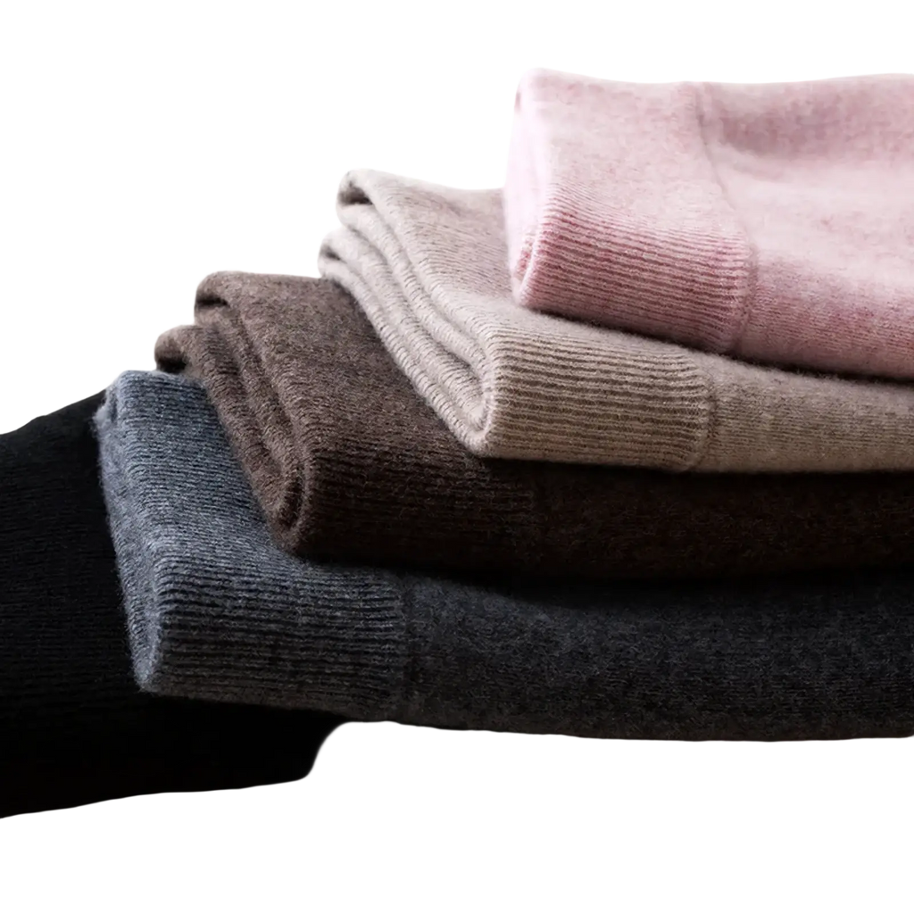 Stack of soft knit women’s shirts in dusty rose beige charcoal gray and black displayed with wool knit midi skirt
