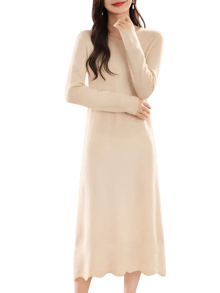 A soft cream-colored wool knit sweater dress with long sleeves, a flattering fit, and scalloped hem