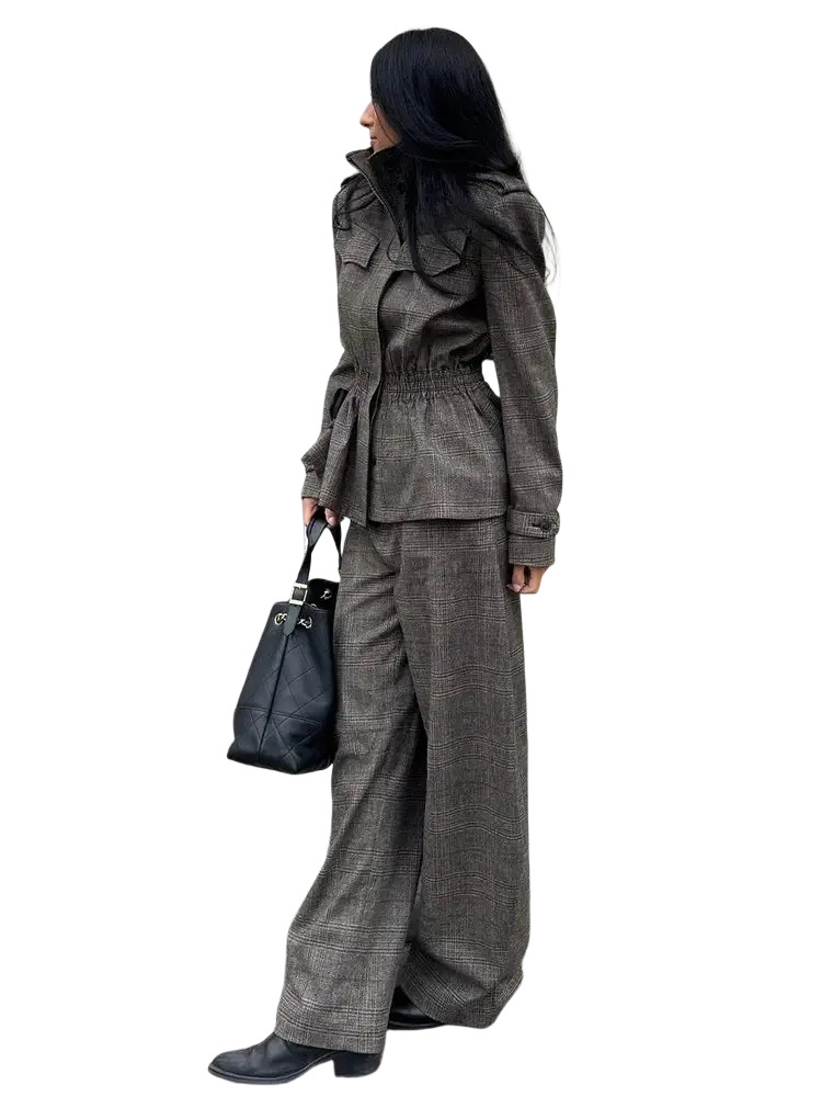 Black leather tote bag with silver hardware and white interior lining complementing wool plaid peplum blazer and trousers suit