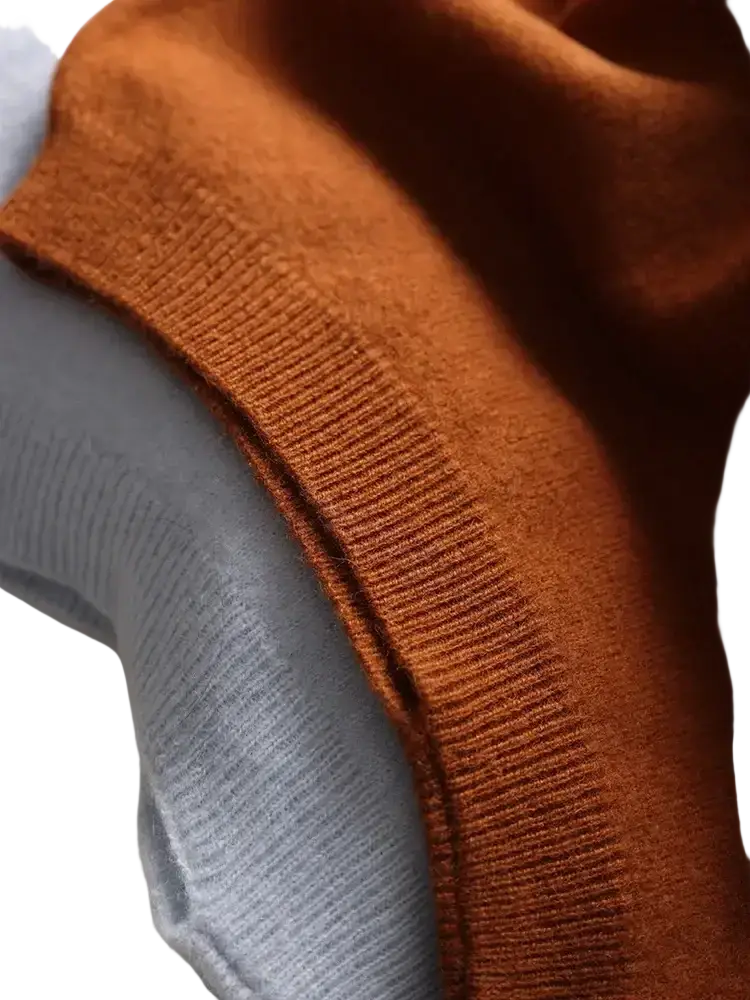 A warm rust-colored ribbed knit sweater sleeve layered under a soft gray wool shawl wrap scarf for women