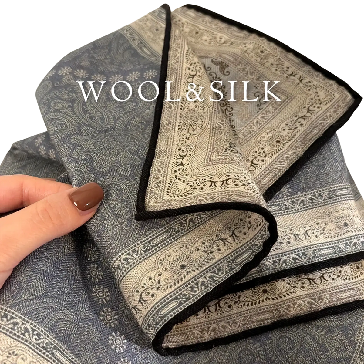 A sophisticated gray and cream paisley wool silk pocket square with a contrasting black border for formal wear