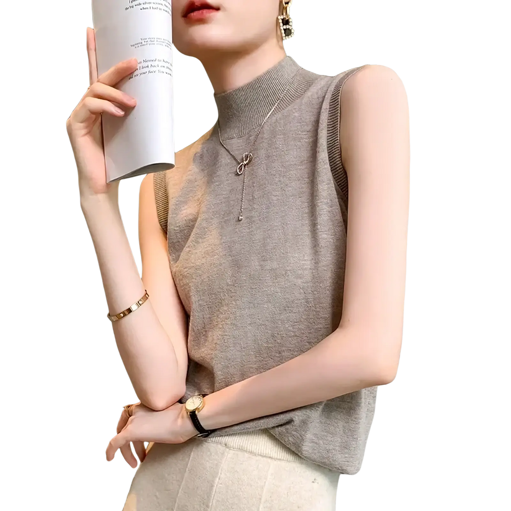 A soft sleeveless beige wool turtleneck sweater vest with ribbed detailing along the armholes and high neckline
