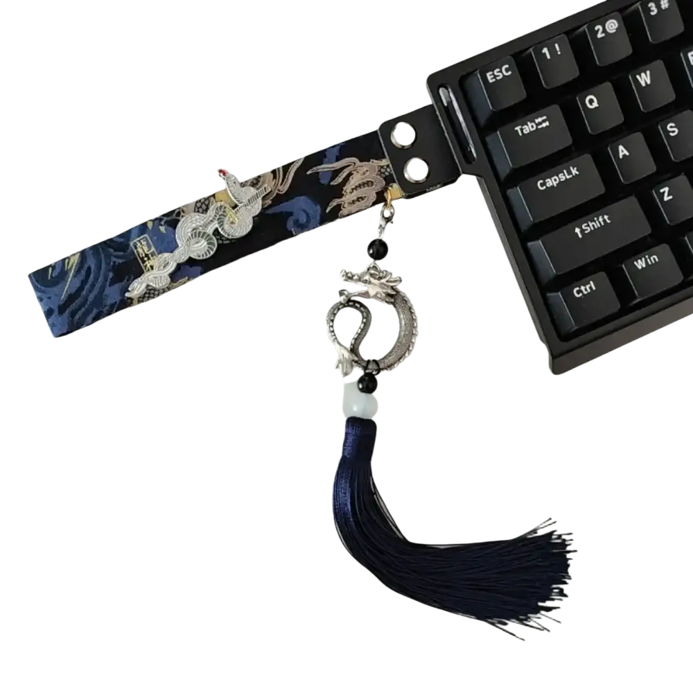 A navy blue fabric Wooting keyboard ribbon strap featuring embroidered silver dragons gold accents and a metallic dragon charm pendant