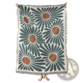 A cozy cream-colored woven cotton throw blanket with bold oversized daisies and soft frayed edges