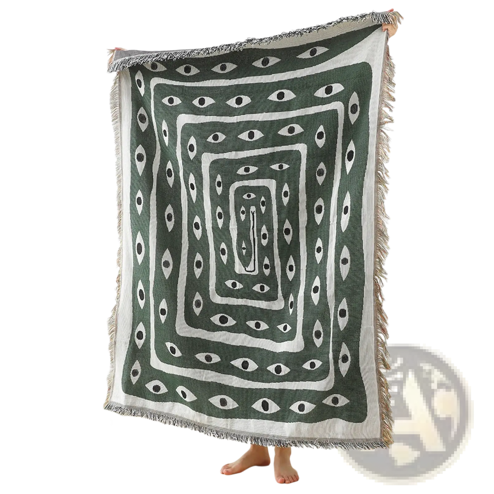A dark green woven cotton throw blanket with white geometric concentric rectangles and eye motifs, fringed edges