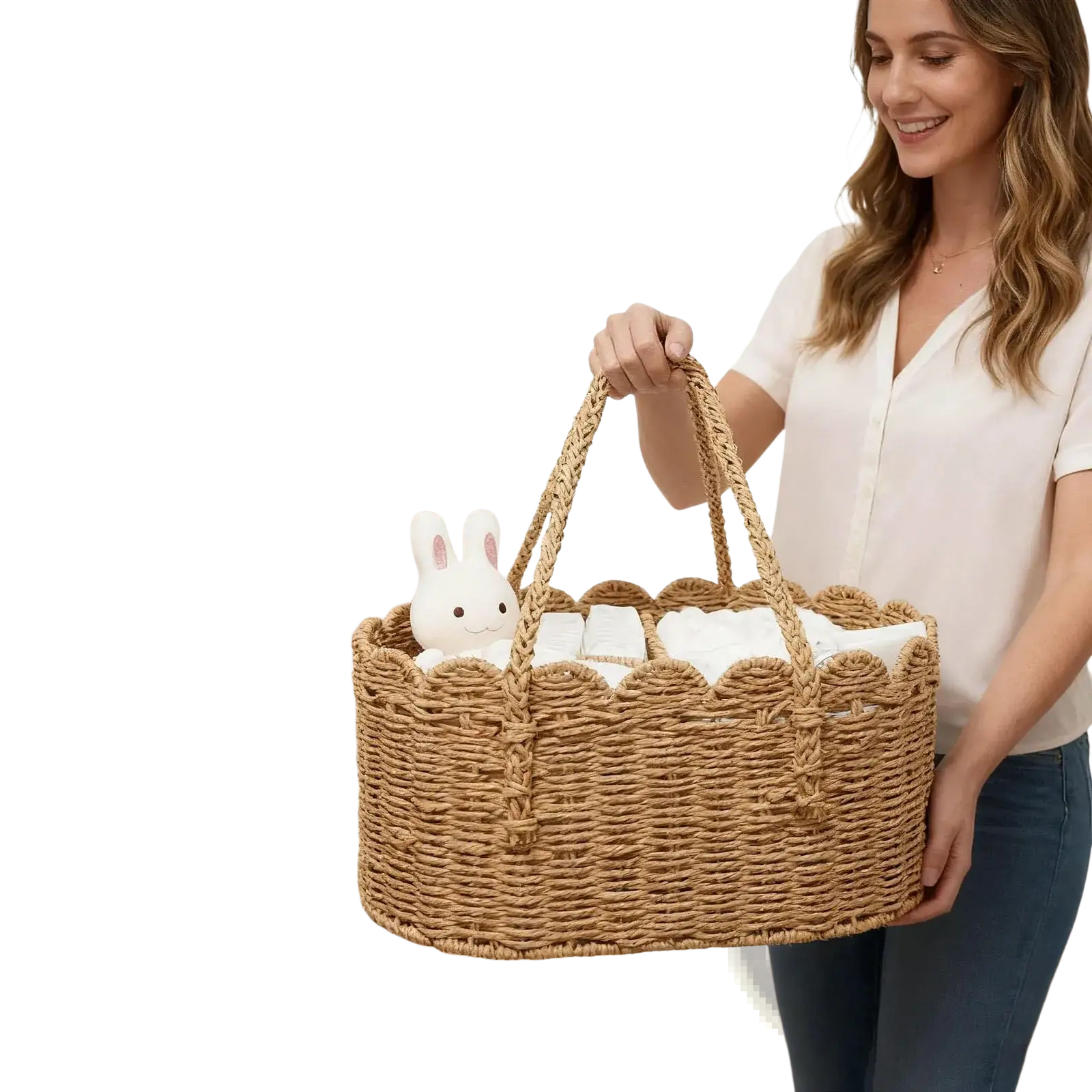 Woven diaper caddy made of natural wicker with scalloped edges and handles holding white baby items