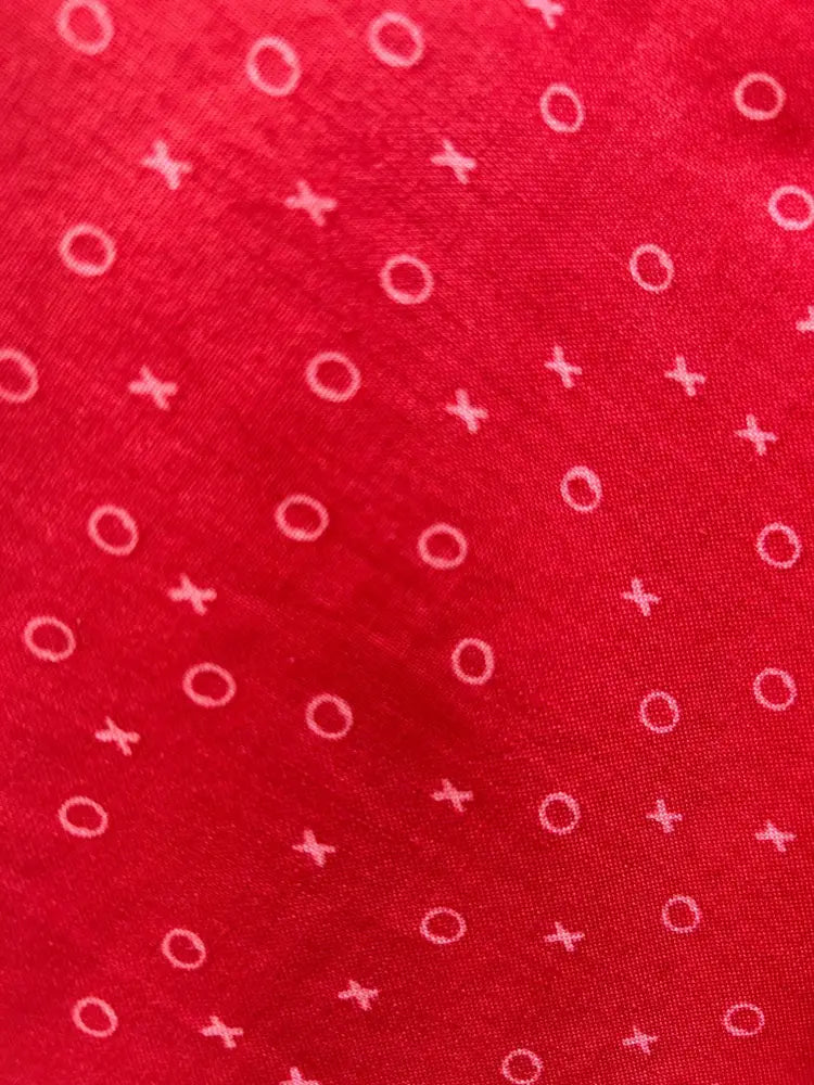 Red cotton skater skirt with elastic waist featuring a xoxo print of white circles and crosses on red fabric