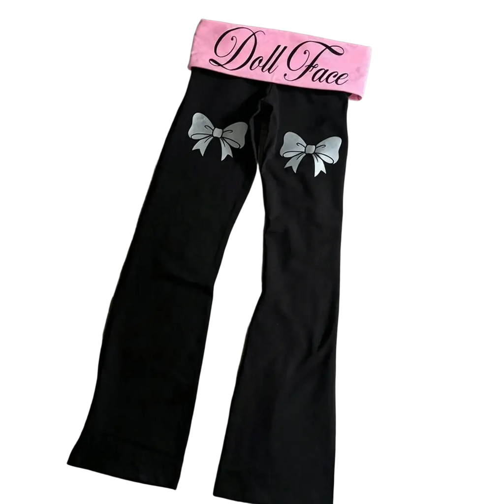 Black flare leggings with pink waistband featuring doll face script and silver bow designs on the thighs