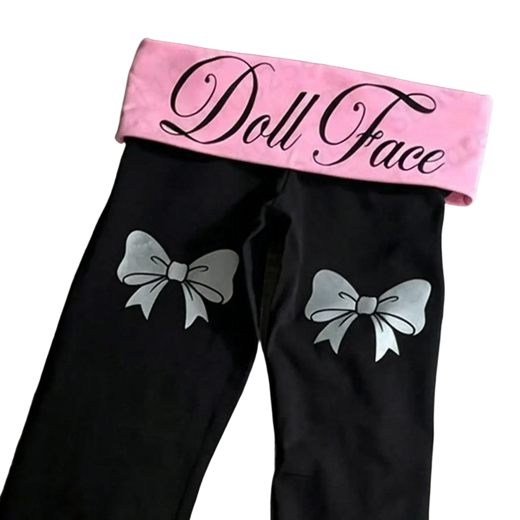 Black y2k flare leggings with silver bow designs and pink elastic waistband featuring doll face logo in black cursive