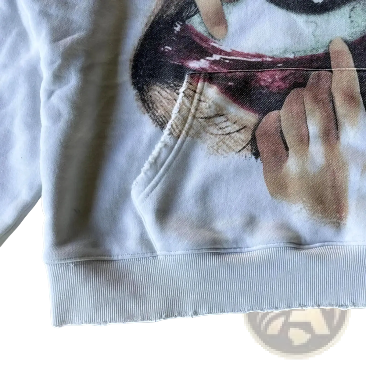 White oversized hoodie featuring a detailed graphic print of a hand holding a face with dark lips and muted skin tones