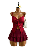 A vibrant red y2k high waist tie two piece swimsuit with a ruched knotted top and layered tiered skirt with side ties