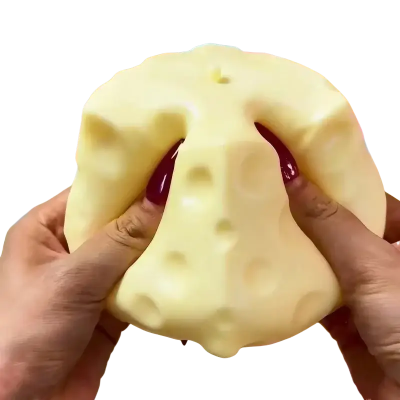 Yellow cheese squishy stress relief toy with a pale yellow textured surface featuring small holes and red accents