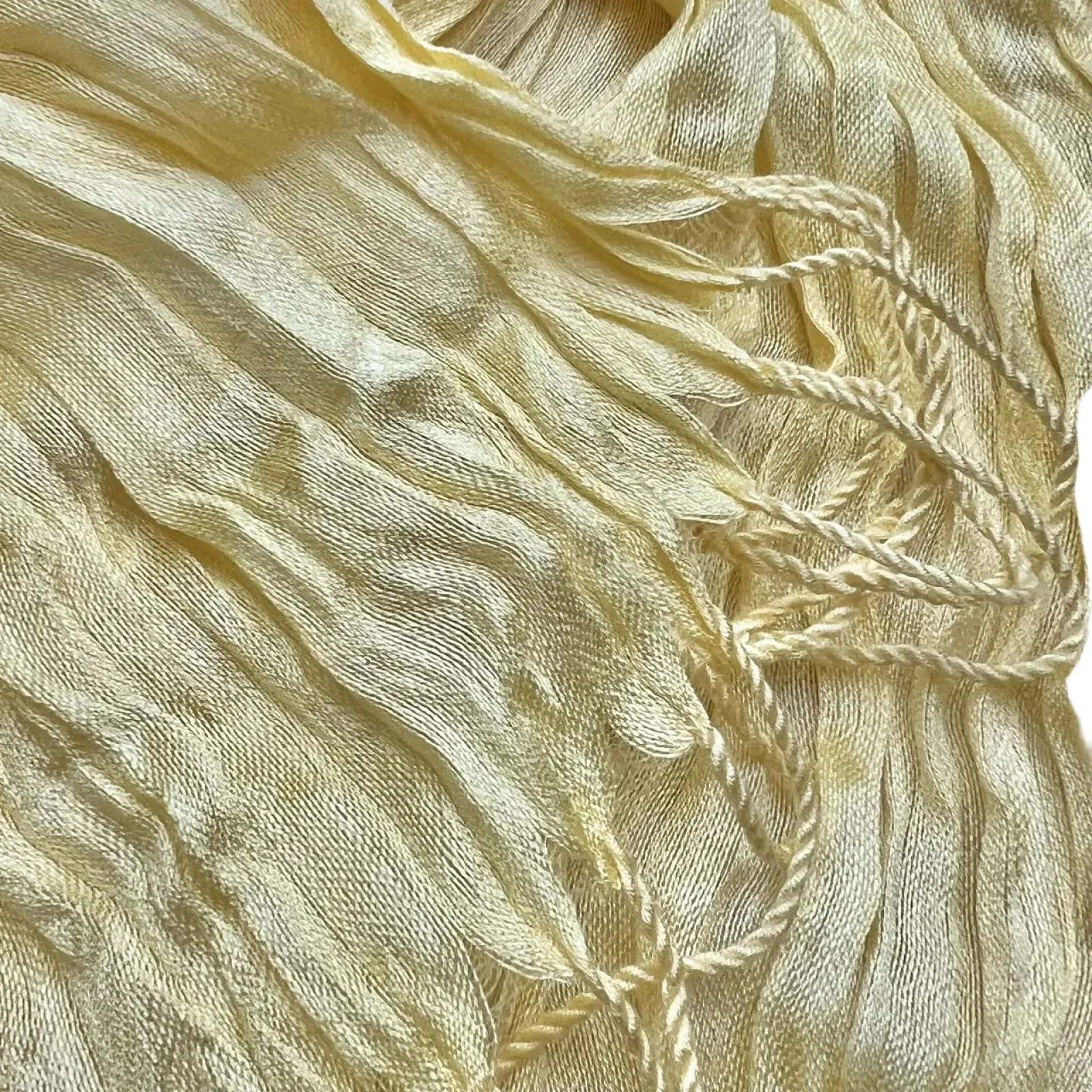 A delicate pale yellow crinkle scarf made of textured summer silk with soft pleats and twisted cream tassels